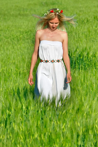 Jeune fille marche dans le champ vert — Photo