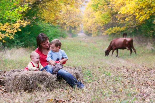 Glad mamma med två barn i höst park — Stockfoto