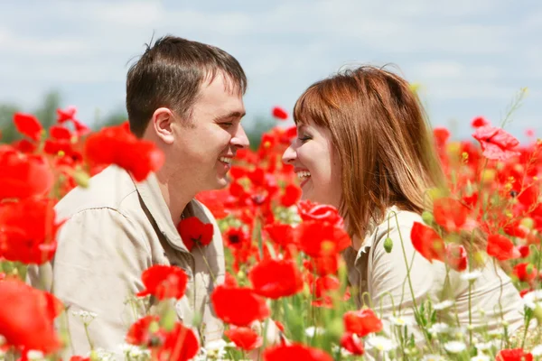 Feliz pareja en rojo amapolas campo — Foto de Stock