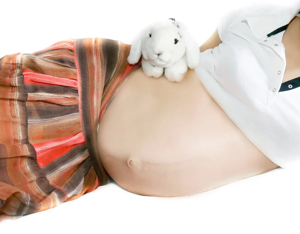 Pregnant woman with toy rabbit over white — Stock Photo, Image