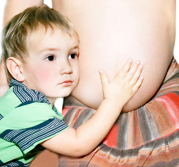 Menino ouvindo o bebê por nascer na barriga de sua mãe — Fotografia de Stock