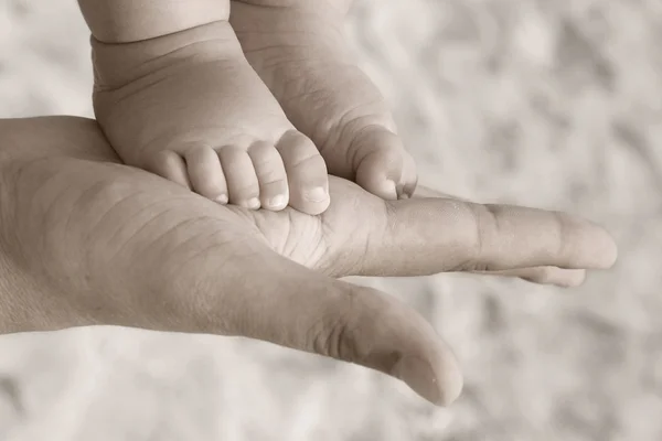 Baby foot on parent hand — Stock Photo, Image
