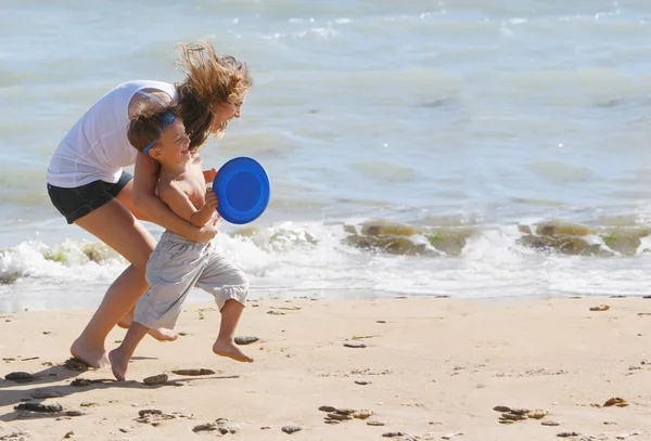 Mãe feliz e filho brincando na praia — Fotografia de Stock