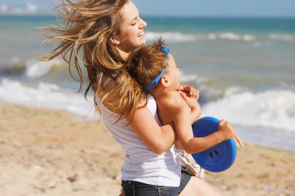 Felice madre e figlio che giocano sulla spiaggia — Foto Stock