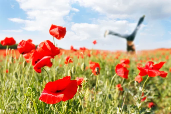Jumping girl in poppy field — Stock Photo, Image