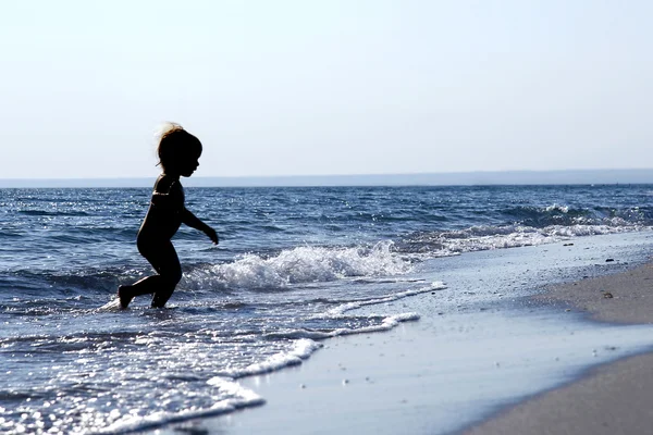 바다에서 실행 중인 아기의 실루엣 — 스톡 사진