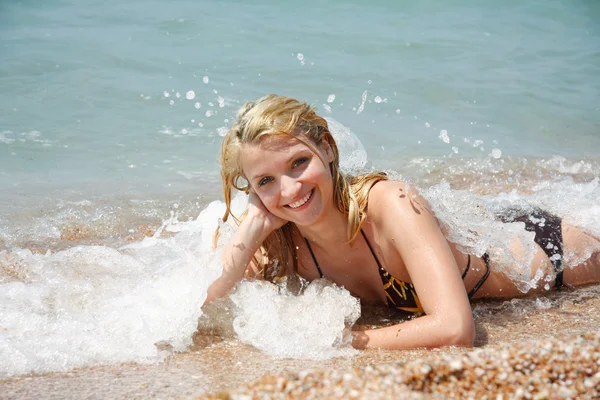 Jovem menina feliz deitado na praia em gotas de água — Fotografia de Stock