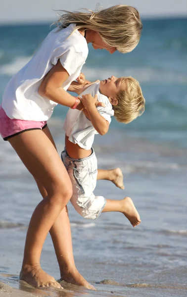 Mor och son spelar på stranden — Stock fotografie
