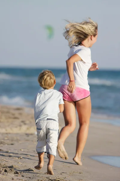 Mãe e filho correndo na praia — Fotografia de Stock