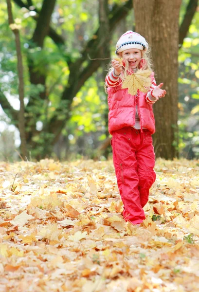 Młoda dziewczyna szczęśliwy grając w parku jesień — Zdjęcie stockowe