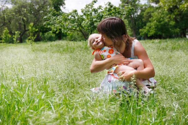 Gelukkig moeder en dochter op natuurlijke achtergrond — Stockfoto
