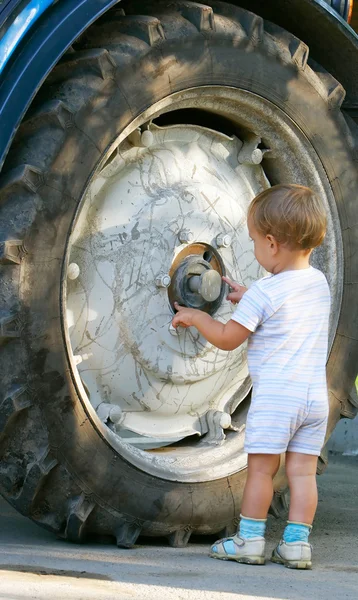 Kleine jongen in de buurt van grote vrachtwagen wiel — Stockfoto