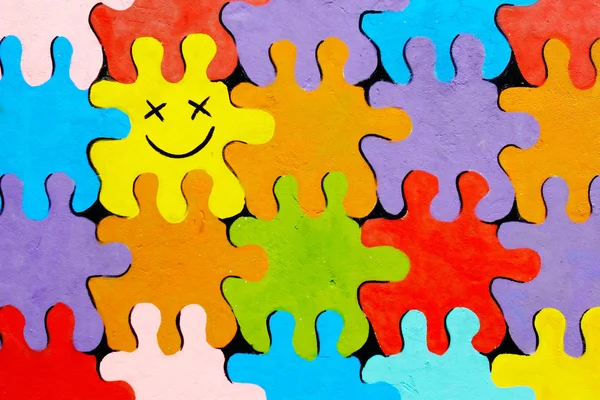 Puzzle colorati dipinti su muro di pietra — Foto Stock