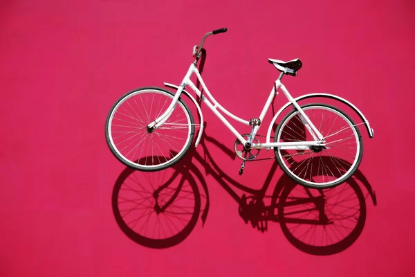 White bike and its shadow over red — Stock Photo, Image