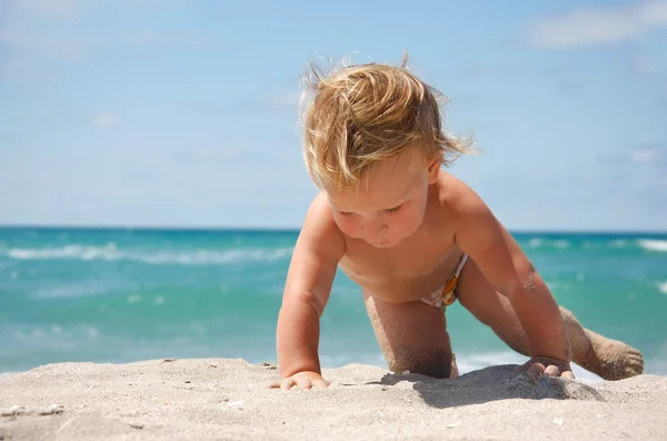 Close up of baby on sand beach — Stock Photo, Image