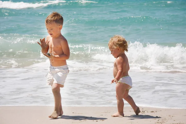 Iki çocuk kumsalda oynarken — Stok fotoğraf