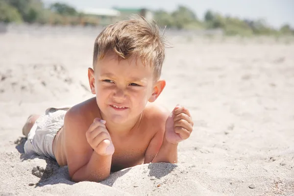 Niño tendido en la playa de arena —  Fotos de Stock