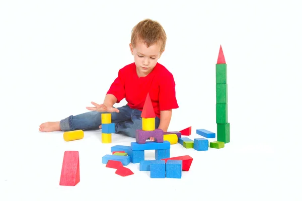 Chlapec hraje s stavební bloky nad bílá — Stock fotografie
