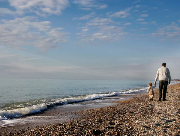 Père et fils s'en vont sur la plage de galets — Photo