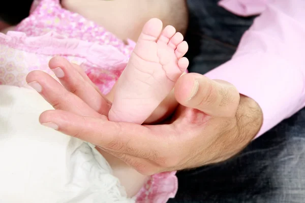 Pie de bebé en la mano del padre — Foto de Stock
