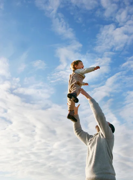 Vater und Sohn spielen auf Himmelshintergrund — Stockfoto