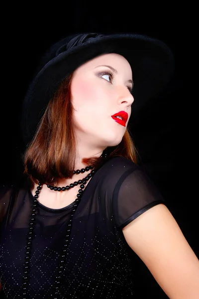 Elegante vrouw in balck jurk en hoed via zwart — Stockfoto