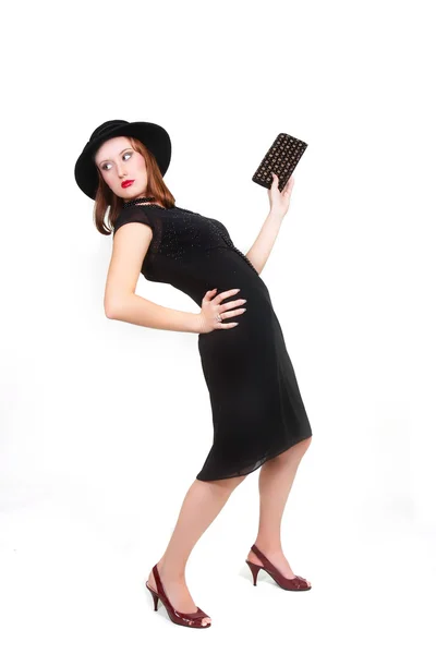 Chica atractiva en vestido negro y sombrero posando sobre blanco —  Fotos de Stock