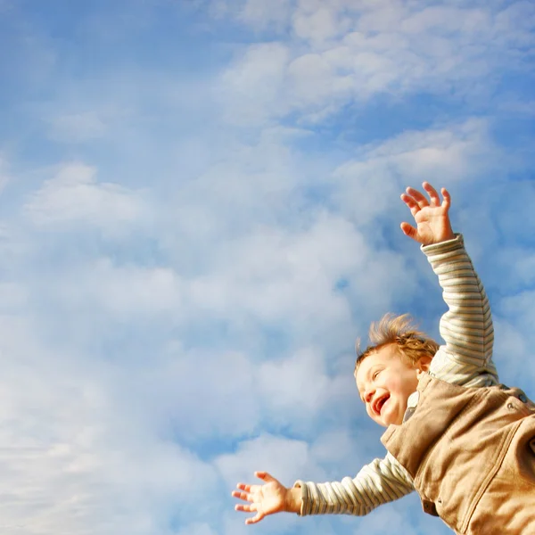 Criança feliz no fundo do céu brilhante — Fotografia de Stock