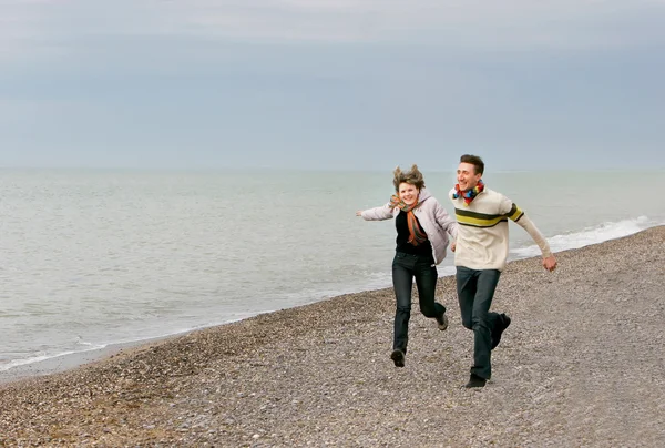Ungt par har det sjovt på stranden - Stock-foto