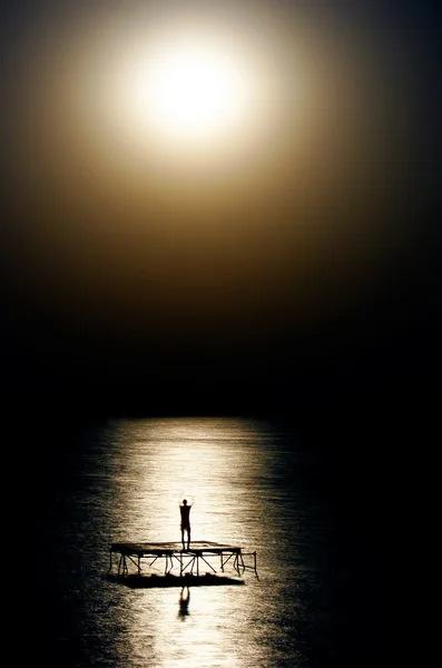 Person tanzt im Wasser im Mondlicht — Stockfoto