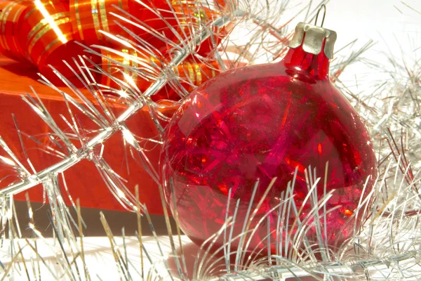 Caja de regalo, bola de Navidad y oropel sobre blanco — Foto de Stock