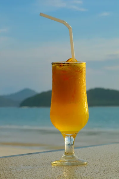 Glass of juice against seascape — Stock Photo, Image