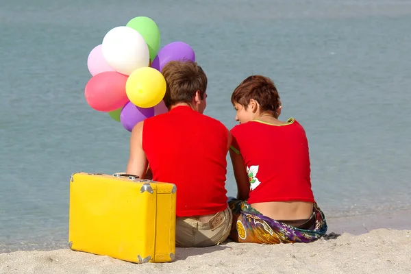 Renkli balonlar ile sahilde iki kişi — Stok fotoğraf