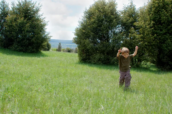 Garçon heureux courir sur fond naturel — Photo