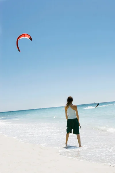Κορίτσι κοιτάζοντας kite surfer στη θάλασσα — Φωτογραφία Αρχείου