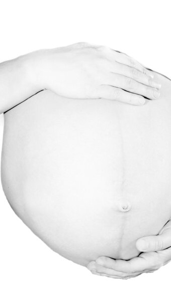 pregnant woman holding her belly over white