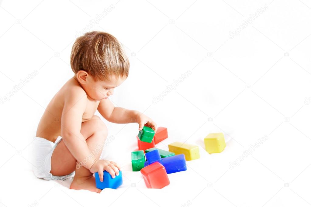 Toddler playing with cubes over white