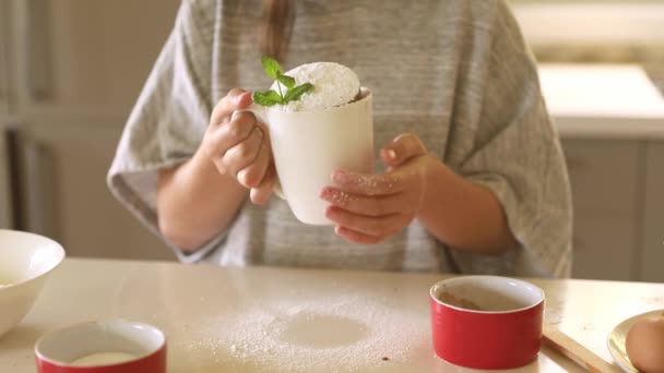 Criança menina segurando bolo em uma caneca, assando em casa com crianças, preparação de sobremesa — Vídeo de Stock