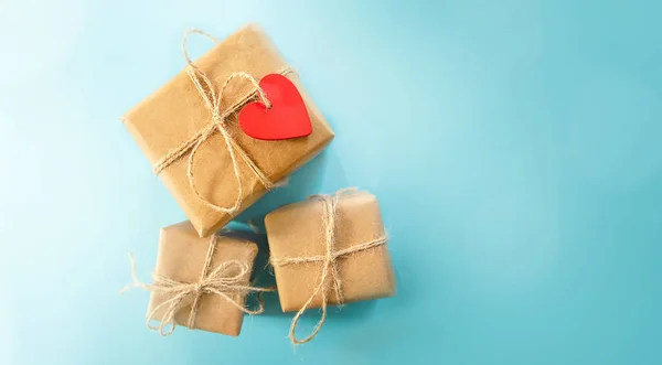 Confezione regalo avvolto con cuore rosso shped tag su sfondo blu, spazio per testo, annuncio, promo, vacanze saluto e concetto di celebrazione — Foto Stock