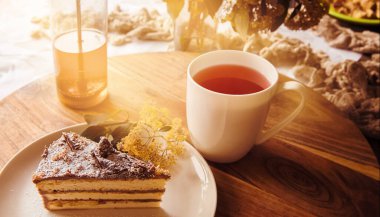 Sabah kahvaltıda ya da otelde servis edilen çikolatayla süslenmiş sünger kekli çay hayattan ve lezzetli yemek konseptinden keyif alıyor.