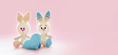 Pembe arka planda kalp şeklinde oyuncakları olan sevimli oyuncak tavşancık, arkadaşlık, aşk ya da ilgi konsepti, sevgililer günü kartı şablonu