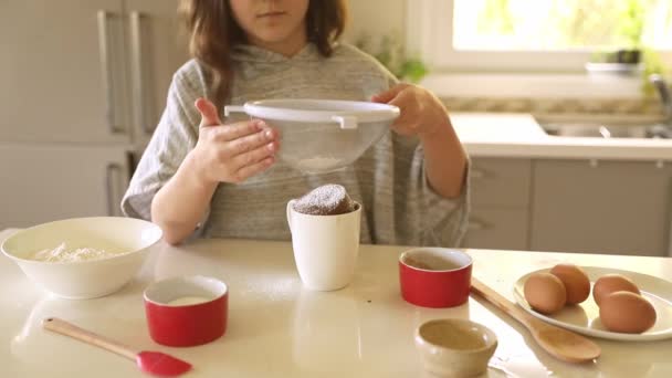 Dítě dívka zdobení dort v hrnku, pečení doma s dětmi, příprava dezertů — Stock video