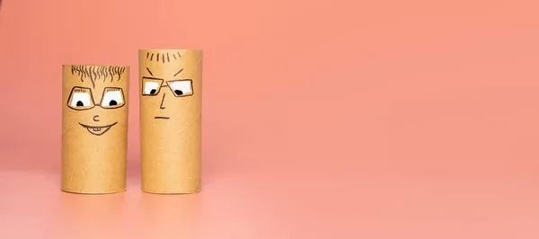 Personaggi realizzati con rotolo di carta igienica con viso dipinto che esprimono felicità o soddisfazione su sfondo rosa, concetto di gruppo di emozioni, idee fai da te per la lavorazione con i bambini — Foto Stock