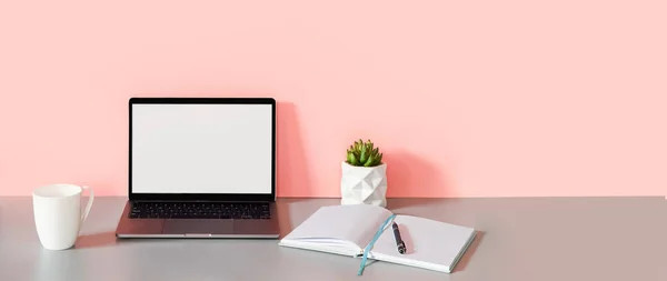 Concepto de negocio, trabajo desde casa, freelance, redacción, vista frontal de la computadora portátil y cuaderno abierto con páginas en blanco sobre fondo rosa — Foto de Stock