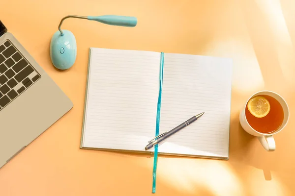 Flatlay negócio, trabalhar em casa, freelance, copywriting, laptop vista superior, notebook com páginas em branco e xícara de chá em fundo bege ou marrom claro — Fotografia de Stock