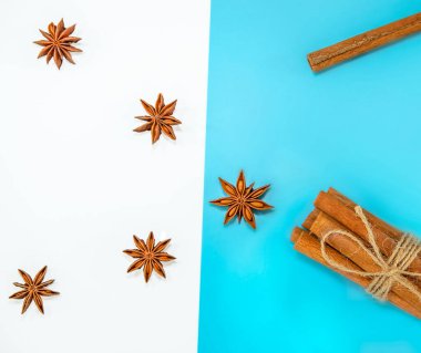 Tarçın çubukları ve eldiven yıldızları beyaz ve mavi arkaplanda izole edilmiş, fırın malzemeleri, kopyalama alanı