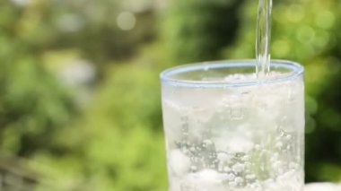 Bir bardak köpüklü içme suyu, su sıçrama tacı, ışık ve gölgeli bulanık arka plan. Saflık, içme suyu, sağlıklı yaşam tarzı ya da tıbbi konsepti