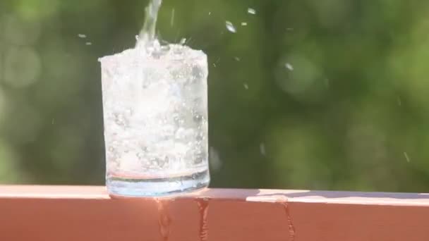 気泡のある飲料水のガラス水の冠光と影のある自然なぼやけた背景。純度、飲料水、健康的なライフスタイル、医療の概念 — ストック動画