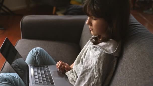 Inomhus porträtt av pre-teen flicka gör läxor på nätet eller surfa på internet, mdeia teknik, digital kommunikation eller shopping, tonåring livsstil — Stockvideo