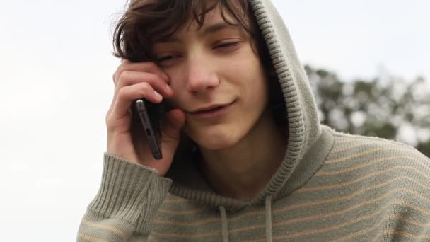 Adolescent garçon avec téléphone portable sur fond naturel, communication mobile, technologie numérique — Video